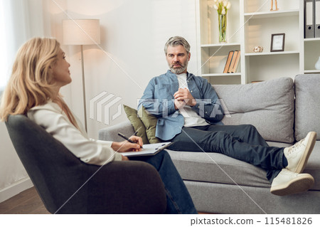 Woman psychologist discusses solutions and support with her troubled male patient in office Woman psychologist discusses solutions and support with her troubled male patient in office 115481826