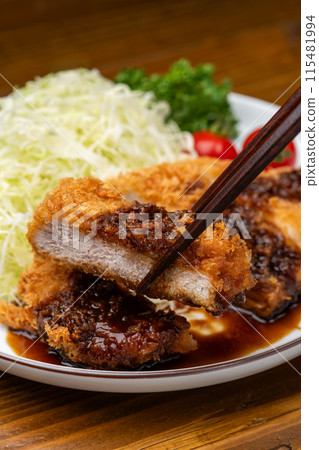 Pick up the crispy pork cutlet with chopsticks 115481994
