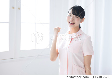 A woman in a white coat, an Asian (Japanese) nurse's fist pump gives an image of success, also good for job hunting 115483629