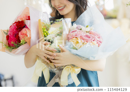 Young woman holding a bouquet of flowers Young woman holding a bouquet of flowers 115484129
