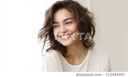 Portrait of beautiful brunette young woman with shaggy hairstyle smiling cheerfully, showing her white teeth to camera while feeling happy on white background 115484307