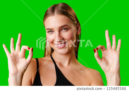 Young Woman Giving Thumbs Up Sign on Green Screen Young Woman Giving Thumbs Up Sign on Green Screen 115485588