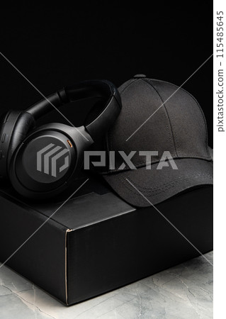 Baseball cap with black headphones on dark background 115485645