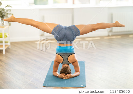 Girl teacher yoga working out practice headstand, shirshasana 115485690
