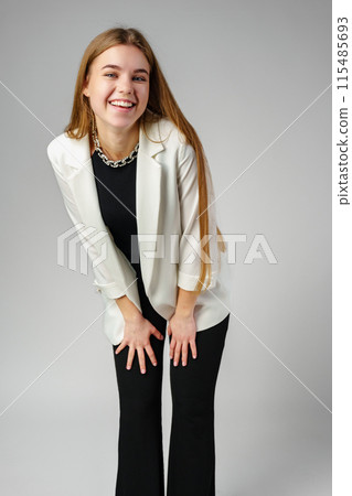 Woman in Black Top and White Jacket Posing in Studio 115485693
