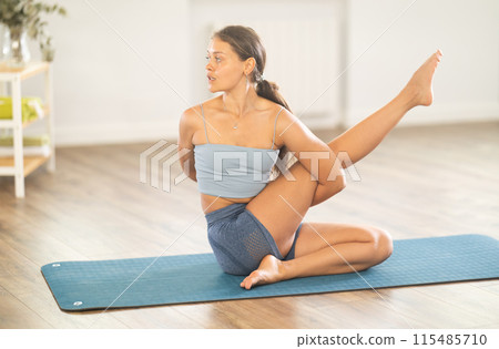 Experienced woman yoga trainer performing different youga pose on mat 115485710