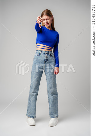 Young Woman Pointing Finger Down at Camera in studio Young Woman Pointing Finger Down at Camera in studio 115485713
