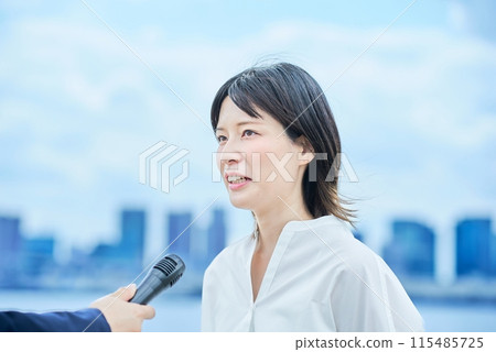 年輕女子在戶外接受採訪 年輕女子在戶外接受採訪 115485725