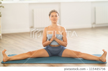 Lover of active lifestyle on yoga mat perform doing Upavishta Konasana in gym Lover of active lifestyle on yoga mat perform doing Upavishta Konasana in gym 115485736