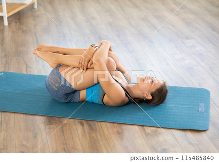 Young woman practicing vinyasa yoga in studio 115485840