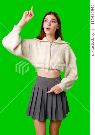 Young Woman in Casual Attire Pondering While Looking Upwards Against a Green Background Young Woman in Casual Attire Pondering While Looking Upwards Against a Green Background 115485943