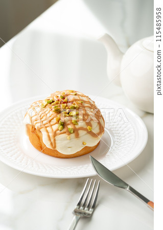 Cinnamon roll bun with icing on plate 115485958