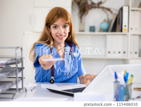 Friendly female doctor giving prescription to patient Friendly female doctor giving prescription to patient 115486010
