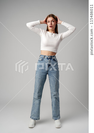 Young Woman Expressing Surprise or Confusion Against a Grey Background Young Woman Expressing Surprise or Confusion Against a Grey Background 115486011