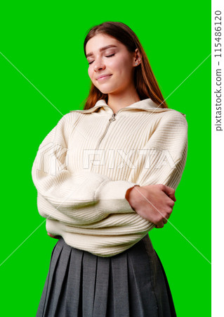A woman wearing a white sweater and a gray skirt stands in a casual pose, showcasing her stylish outfit. A woman wearing a white sweater and a gray skirt stands in a casual pose, showcasing her stylish outfit. 115486120