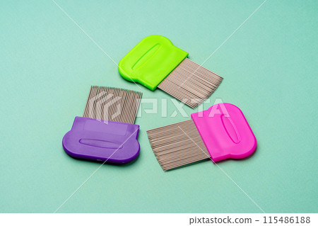 Three combs for lice removing on green background 115486188