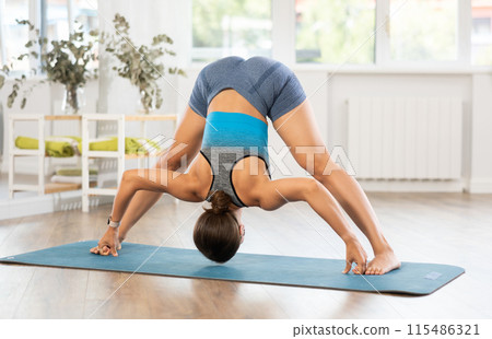 Young woman practicing hatha yoga in studio 115486321