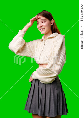Young Woman in White Sweater and Grey Skirt Smiling Against Green Background 115486322