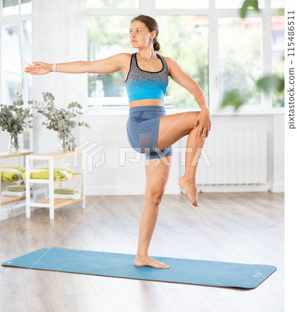Athletic young woman enjoying daily yoga practice in studio Athletic young woman enjoying daily yoga practice in studio 115486511