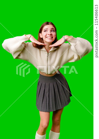 Smiling Young Woman Posing in Casual Clothing Against a Green Background Smiling Young Woman Posing in Casual Clothing Against a Green Background 115486613