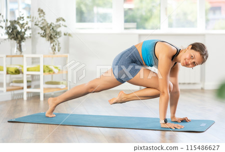 Sporty young woman practicing yoga in serene studio 115486627