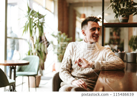 Man in White Sweater Sitting in Chair Man in White Sweater Sitting in Chair 115486639