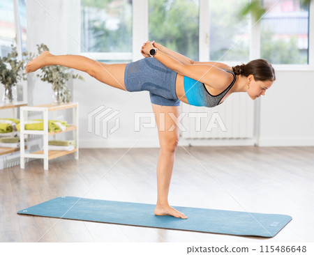 Sporty woman performing Airplane Pose, or Dekasana during yoga session 115486648