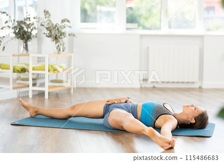 Athletic young woman enjoying daily yoga practice in studio Athletic young woman enjoying daily yoga practice in studio 115486683