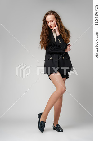 Young Woman in Short Skirt and Jacket Posing for Picture 115486728