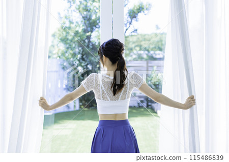 年輕女子打開蕾絲窗簾的後視圖 115486839