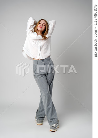 Young Woman in White Shirt Posing for Picture Young Woman in White Shirt Posing for Picture 115486879