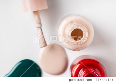 Several opened bottles of nail polish on white background Several opened bottles of nail polish on white background 115487123