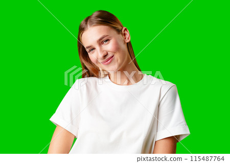 Young Woman in White Shirt Posing for Picture against green background 115487764