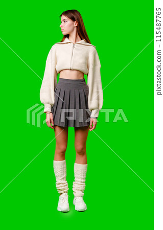Young Woman in Trendy Attire Posing Against a Green Background During Daytime 115487765