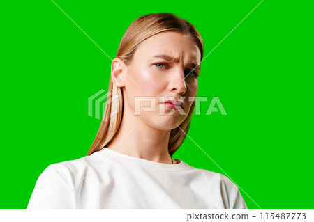 Young Woman With Pursed Lips Expressing Skepticism Against Green Screen Background 115487773