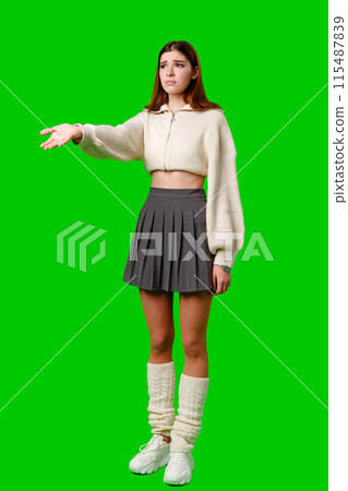 Woman in Skirt and Sweater Pointing at Something 115487839