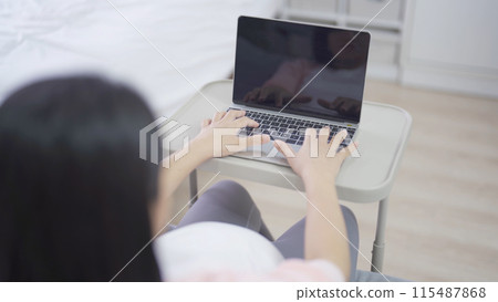 A portrait of happy Asian pregnant woman using, working online with computer laptop notebook tablet device with screen in bedroom at home. Having a baby. Family people lifestyle. Mom love. A portrait of happy Asian pregnant woman using, working online with computer laptop notebook tablet device with screen in bedroom at home. Having a baby. Family people lifestyle. Mom love. 115487868