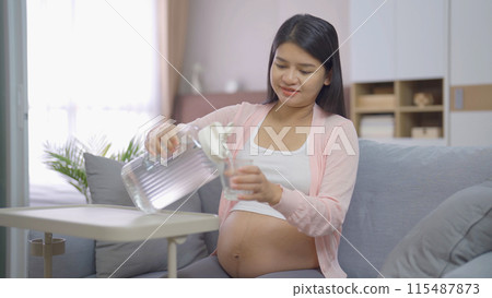 A portrait of happy Asian pregnant woman with medicine pills in bedroom at home. Having a baby. Family people lifestyle. Mom love. 115487873