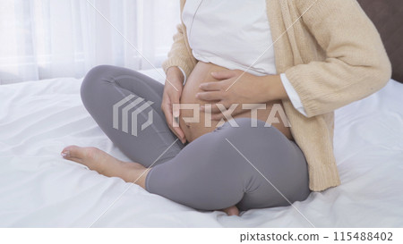 A Portrait of happy Asian pregnant woman in bedroom at home. Having a baby. Family people lifestyle. Love. A Portrait of happy Asian pregnant woman in bedroom at home. Having a baby. Family people lifestyle. Love. 115488402