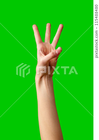 Human Hand Displaying the Number Three Against a Solid Green Background Human Hand Displaying the Number Three Against a Solid Green Background 115488480