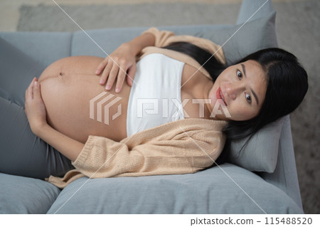 A Portrait of happy Asian pregnant woman in bedroom at home. Having a baby. Family people lifestyle. Love. A Portrait of happy Asian pregnant woman in bedroom at home. Having a baby. Family people lifestyle. Love. 115488520