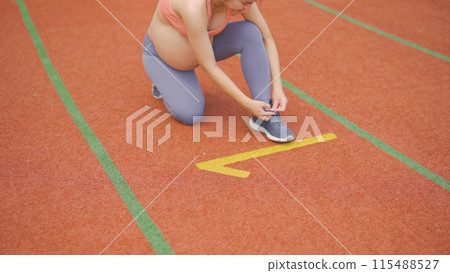 A portrait of happy Asian pregnant woman running on rubber floor, track on a sports stadium. Sport and recreation background. Having a baby. Family people lifestyle. Mom lifestyle. 115488527