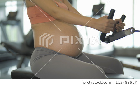 A portrait of happy Asian pregnant woman at gym fitness center club. Having a baby. Training workout. Exercise indoor with sport equipment. Athletic. Family people lifestyle. Mom love. Recreation. 115488617