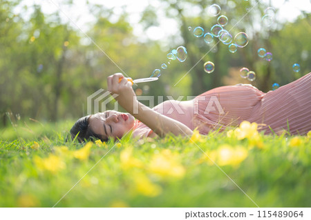 A portrait of happy Asian pregnant woman walking in public garden park on vacation. Love of mother. Having a baby. Family people lifestyle. A portrait of happy Asian pregnant woman walking in public garden park on vacation. Love of mother. Having a baby. Family people lifestyle. 115489064