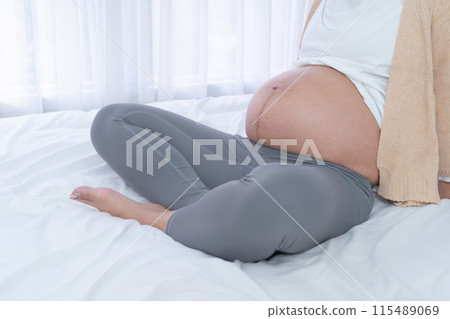 Close up of a Portrait of happy pregnant woman in bedroom at home. Having a baby. Family people lifestyle. Mom love. 115489069
