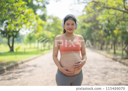 A portrait of happy Asian pregnant woman in yoga class club doing exercise at public garden park. Outdoor sport and recreation. activity with nature trees view. Having a baby. Family people lifestyle. A portrait of happy Asian pregnant woman in yoga class club doing exercise at public garden park. Outdoor sport and recreation. activity with nature trees view. Having a baby. Family people lifestyle. 115489070