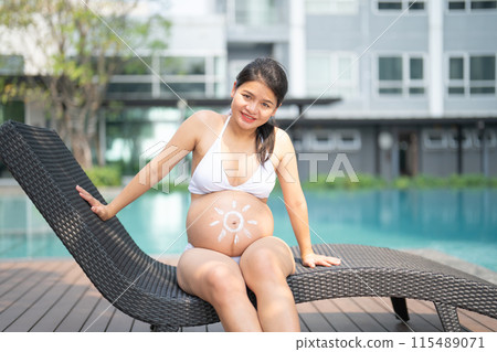 A portrait of happy Asian pregnant woman by the swimming pool. People lifestyle in travel holiday vacation concept. Relaxation. Having a baby. Family people lifestyle. Mom love. 115489071