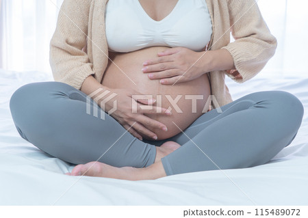 Close up of a Portrait of happy pregnant woman in bedroom at home. Having a baby. Family people lifestyle. Mom love. Close up of a Portrait of happy pregnant woman in bedroom at home. Having a baby. Family people lifestyle. Mom love. 115489072
