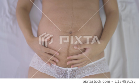 Close up of a Portrait of happy pregnant woman in bedroom at home. Having a baby. Family people lifestyle. Mom love. 115489153