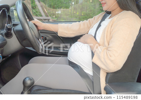A Portrait of happy Asian pregnant woman driving a car vehicle. Having a baby. Family people lifestyle. Mom love. Journey. A Portrait of happy Asian pregnant woman driving a car vehicle. Having a baby. Family people lifestyle. Mom love. Journey. 115489198